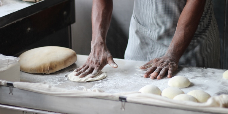 Close-up of a baker’s hands making various shapes out of dough.